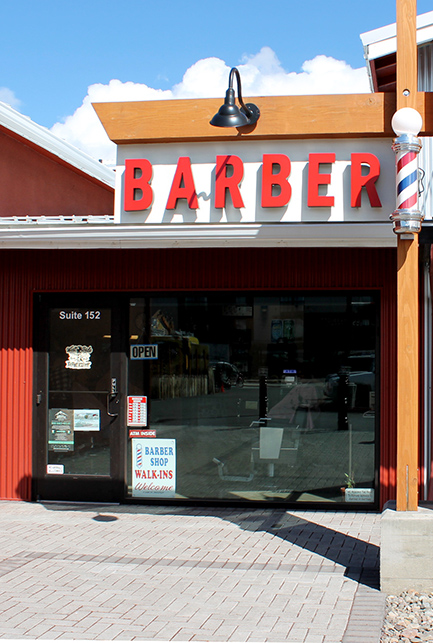The classic red barber sign and blue and white pole outside the shop